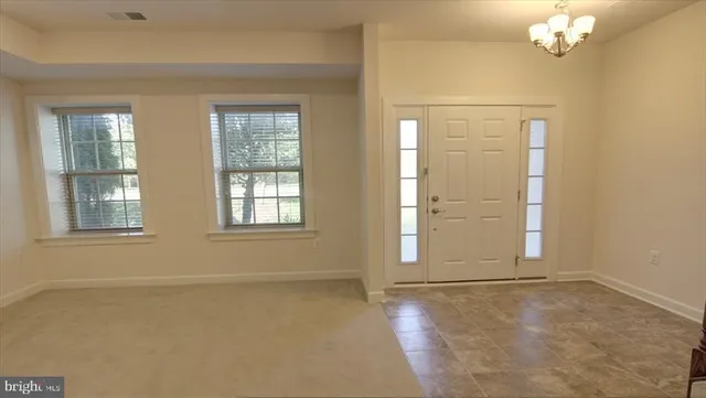 an empty room with windows and chandelier