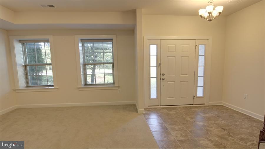 7652 Telamon Way Hanover, MD 21076 - Photo 3 of 34 an empty room with windows and chandelier