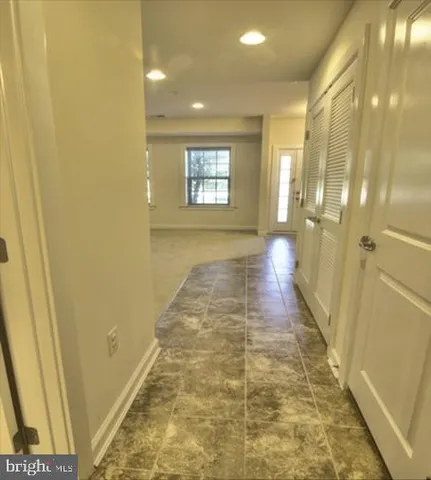 a view of a hallway with wooden floor and shower