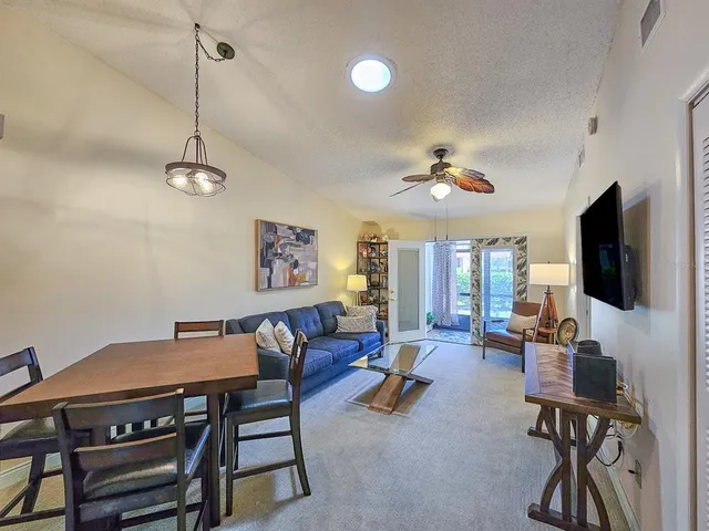 a living room with furniture a flat screen tv and a chandelier