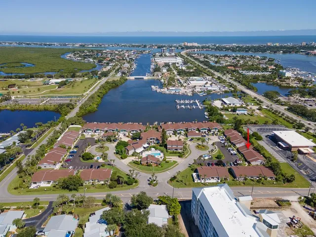 an aerial view of a city with lots of residential buildings ocean and mountain view in back