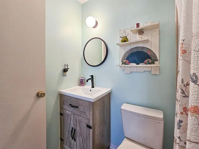 a bathroom with a toilet a sink and a mirror