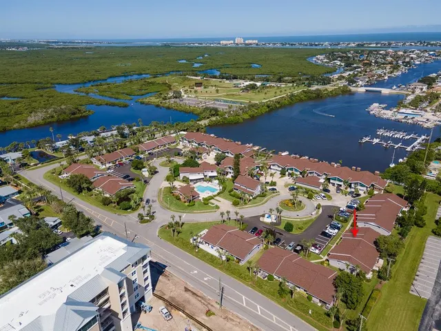 an aerial view of ocean and residential houses with outdoor space