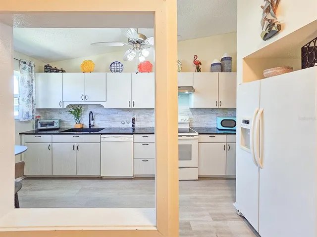 a kitchen with stainless steel appliances granite countertop a refrigerator and a stove