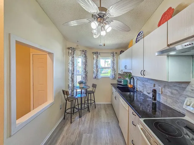 a kitchen with stainless steel appliances granite countertop a sink a stove and chairs