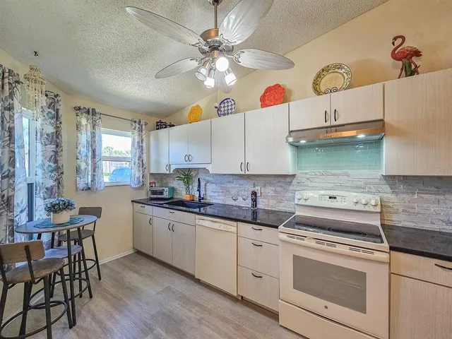 a kitchen with granite countertop cabinets a sink and a stove