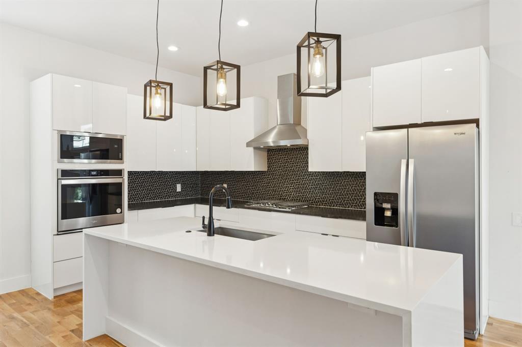 4119 Munger Avenue Dallas, TX 75204 - Photo 6 of 30 a kitchen with stainless steel appliances a counter top space cabinets and refrigerator
