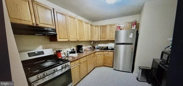 a kitchen with a refrigerator a stove a sink and cabinets