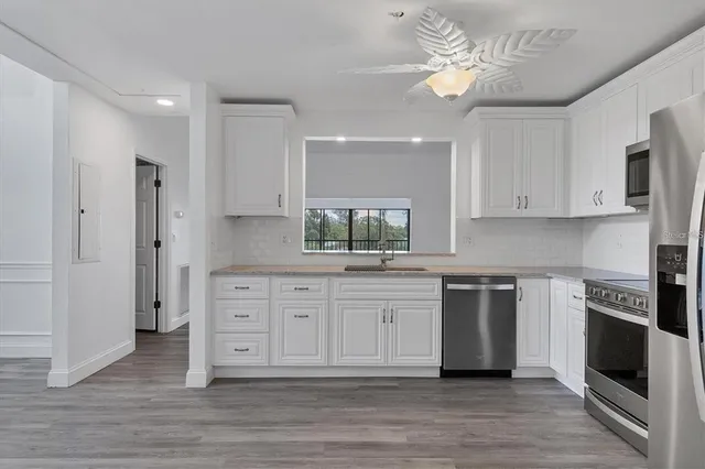 a kitchen with stainless steel appliances granite countertop a stove a sink and a refrigerator