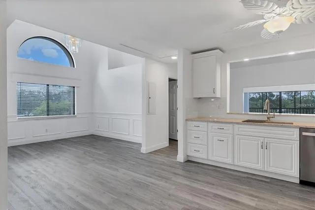 a view of a kitchen with a sink dishwasher and wooden floor