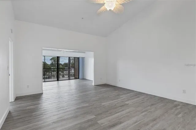 a view of an empty room with wooden floor and a window