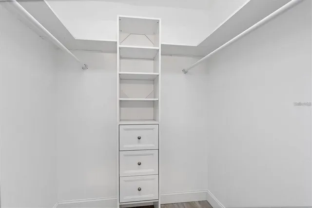 a view of walk in closet with empty racks