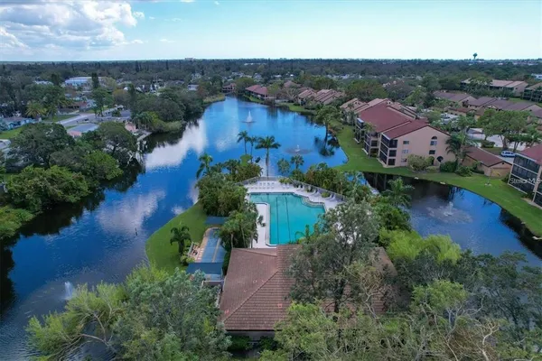 an aerial view of residential houses with outdoor space and lake view