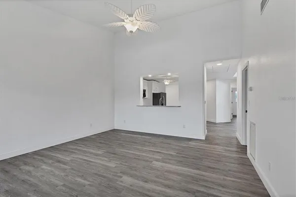 an empty room with wooden floor and ceiling fan