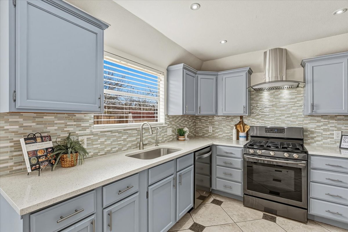 8103 Red Rock Cove Austin, TX 78749 - Photo 13 of 33 a kitchen with a sink a stove cabinets and counter space
