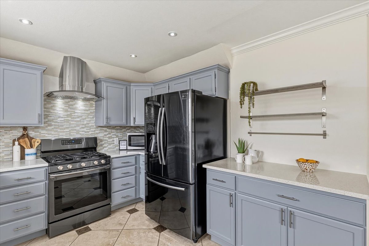 8103 Red Rock Cove Austin, TX 78749 - Photo 15 of 33 a kitchen with stainless steel appliances a refrigerator sink and stove