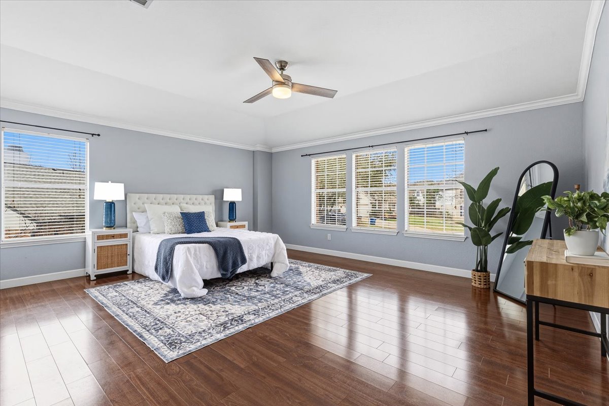 8103 Red Rock Cove Austin, TX 78749 - Photo 17 of 33 a bedroom with a large bed and wooden floor