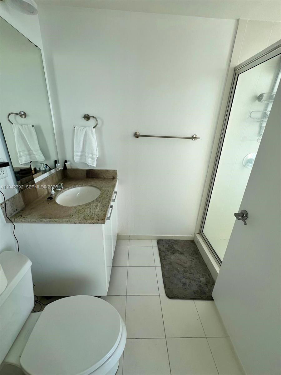 185 Southwest 7th Street, Unit 2601 Miami, FL 33130 - Photo 11 of 17 a bathroom with a granite countertop sink and a mirror