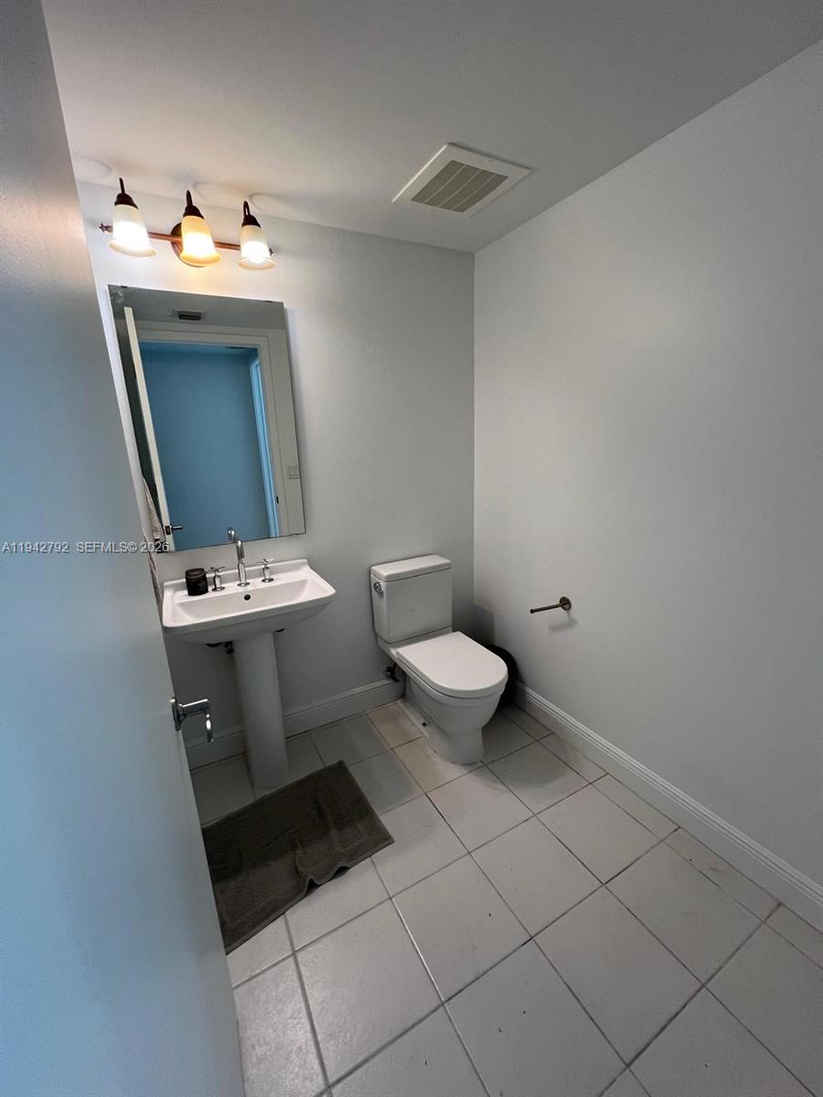 185 Southwest 7th Street, Unit 2601 Miami, FL 33130 - Photo 12 of 17 a bathroom with a sink toilet and mirror