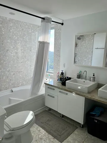 a bathroom with a double vanity sink toilet and shower