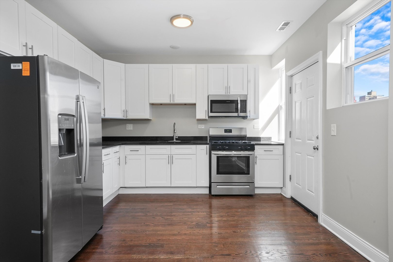6833 South Merrill Avenue, Unit 1 Chicago, IL 60649 - Photo 2 of 10 a kitchen with white cabinets and stainless steel appliances