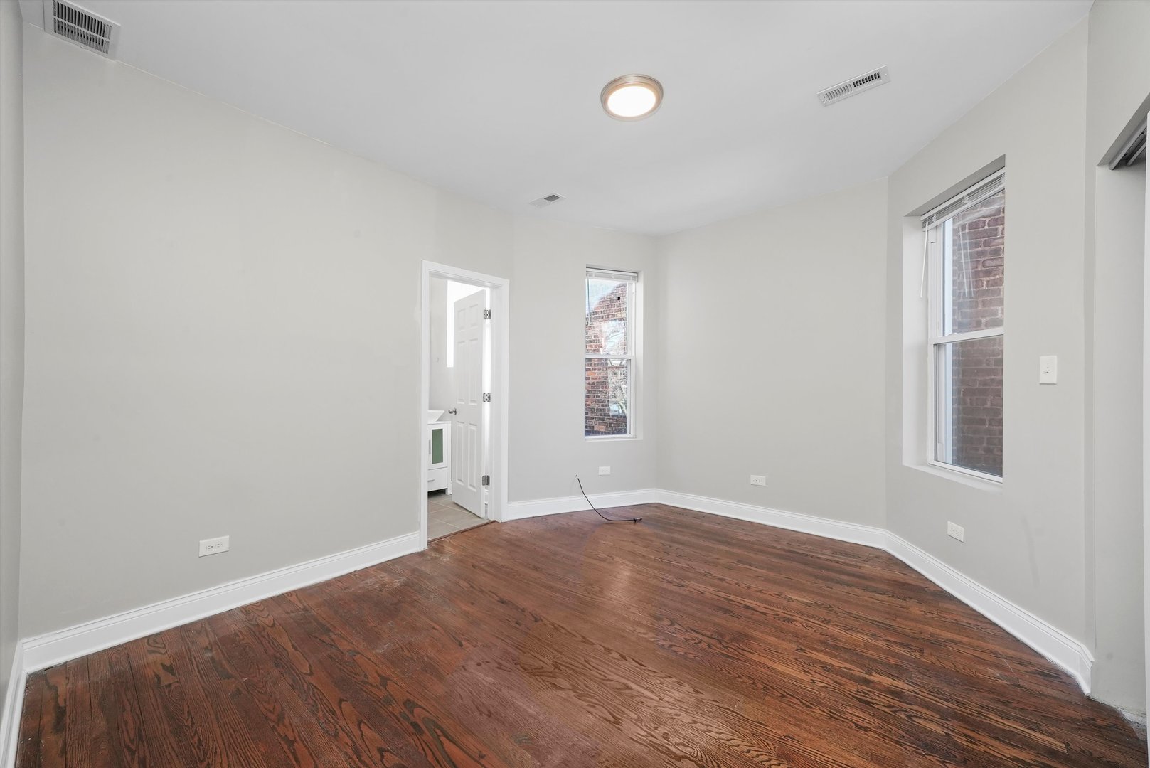 6833 South Merrill Avenue, Unit 1 Chicago, IL 60649 - Photo 5 of 10 wooden floor in an empty room with a window