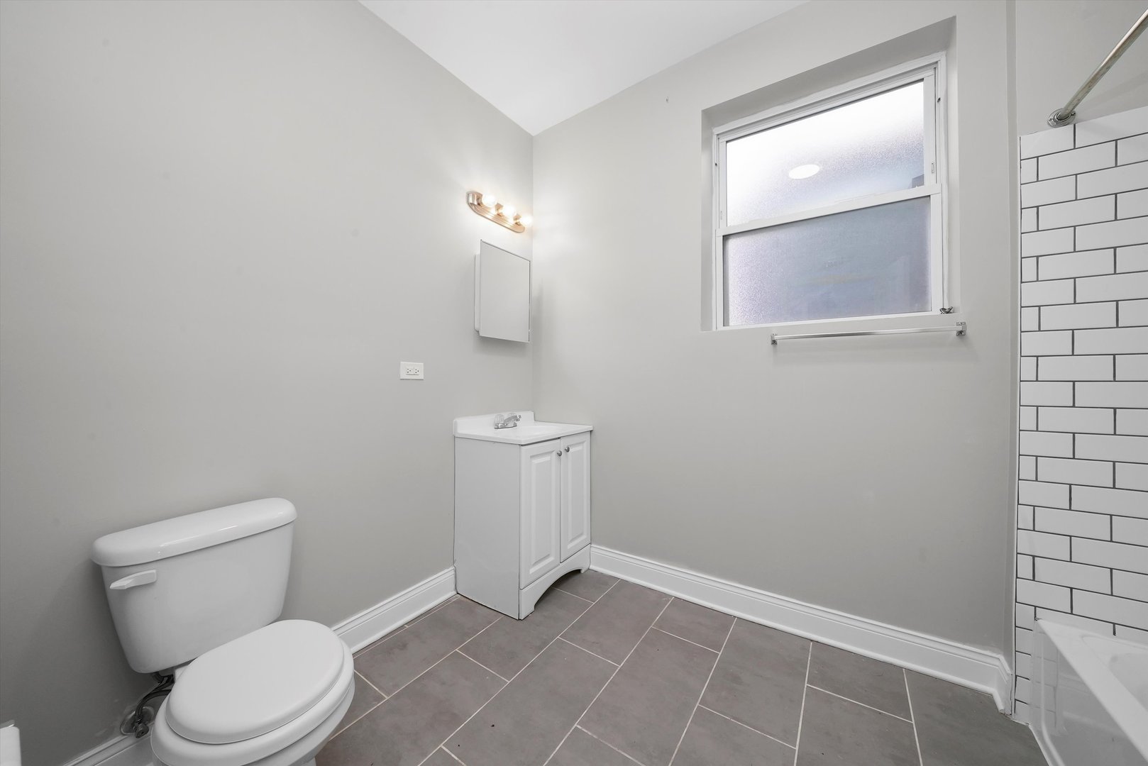6833 South Merrill Avenue, Unit 1 Chicago, IL 60649 - Photo 9 of 10 a white toilet sitting next to a bathroom sink