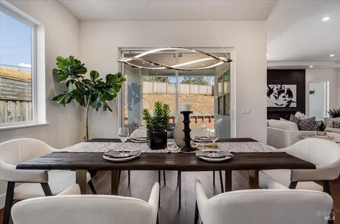 a kitchen with a table chairs and wooden floor