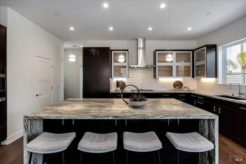 a kitchen with stainless steel appliances granite countertop a table chairs stove refrigerator and cabinets