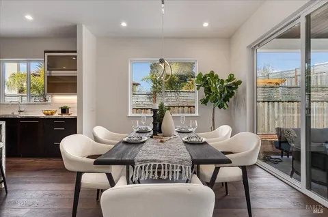 a dining room with furniture a chandelier and wooden floor