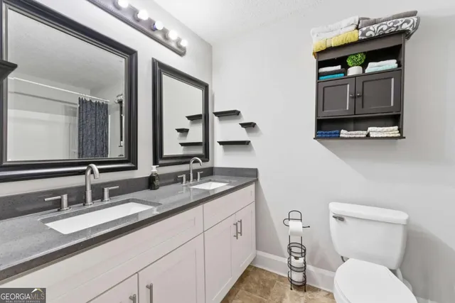 a bathroom with a toilet sink and mirror
