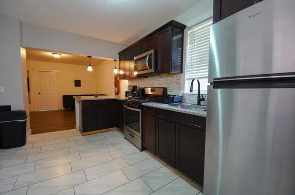 a kitchen with stainless steel appliances granite countertop a refrigerator and a sink