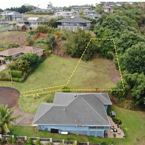 an aerial view of residential houses with outdoor space and parking