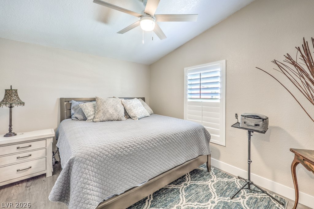 4375 Pinwheel Street Logandale, NV 89021 - Photo 27 of 52 A well-lit bedroom features a vaulted ceiling and a cooling fan for optimal comfort.