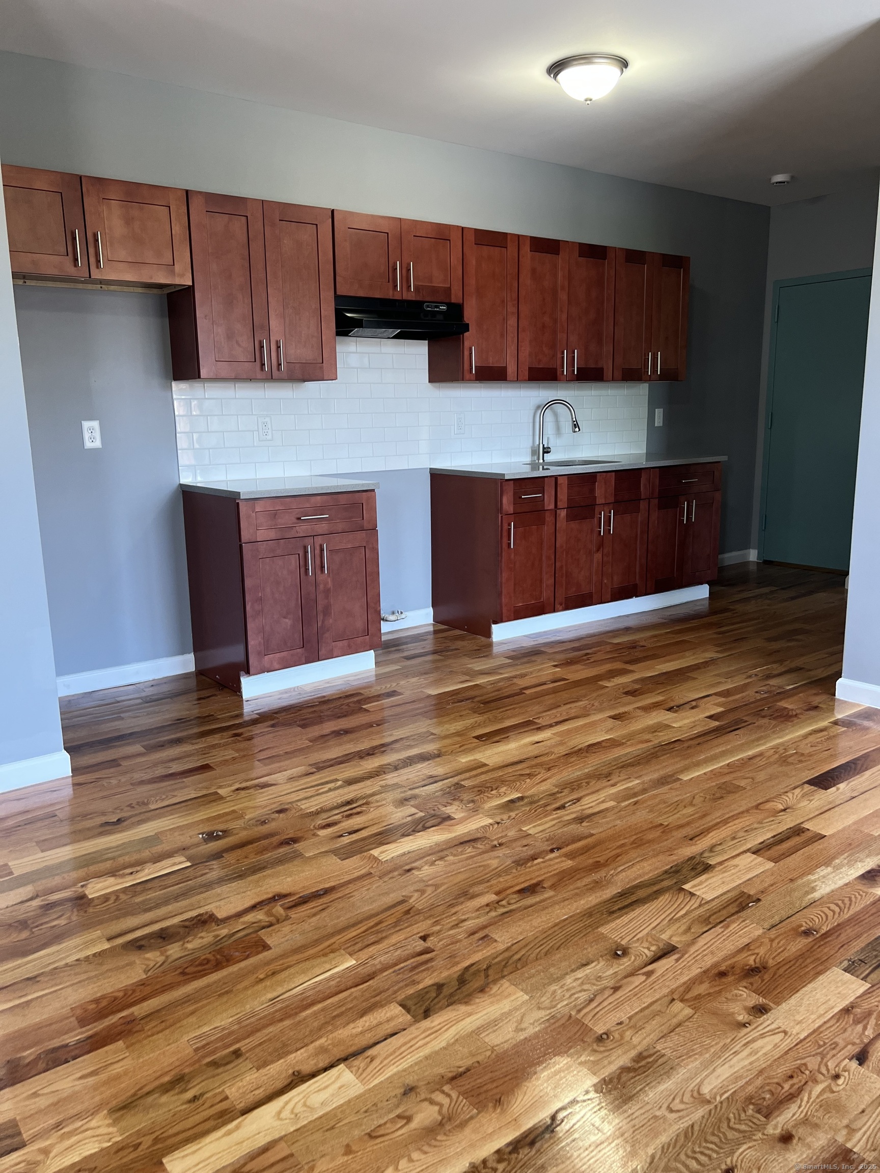 79 Barbour Street, Unit S1 Hartford, CT 06120 - Photo 3 of 8 a kitchen with kitchen island wooden cabinets and granite counter top