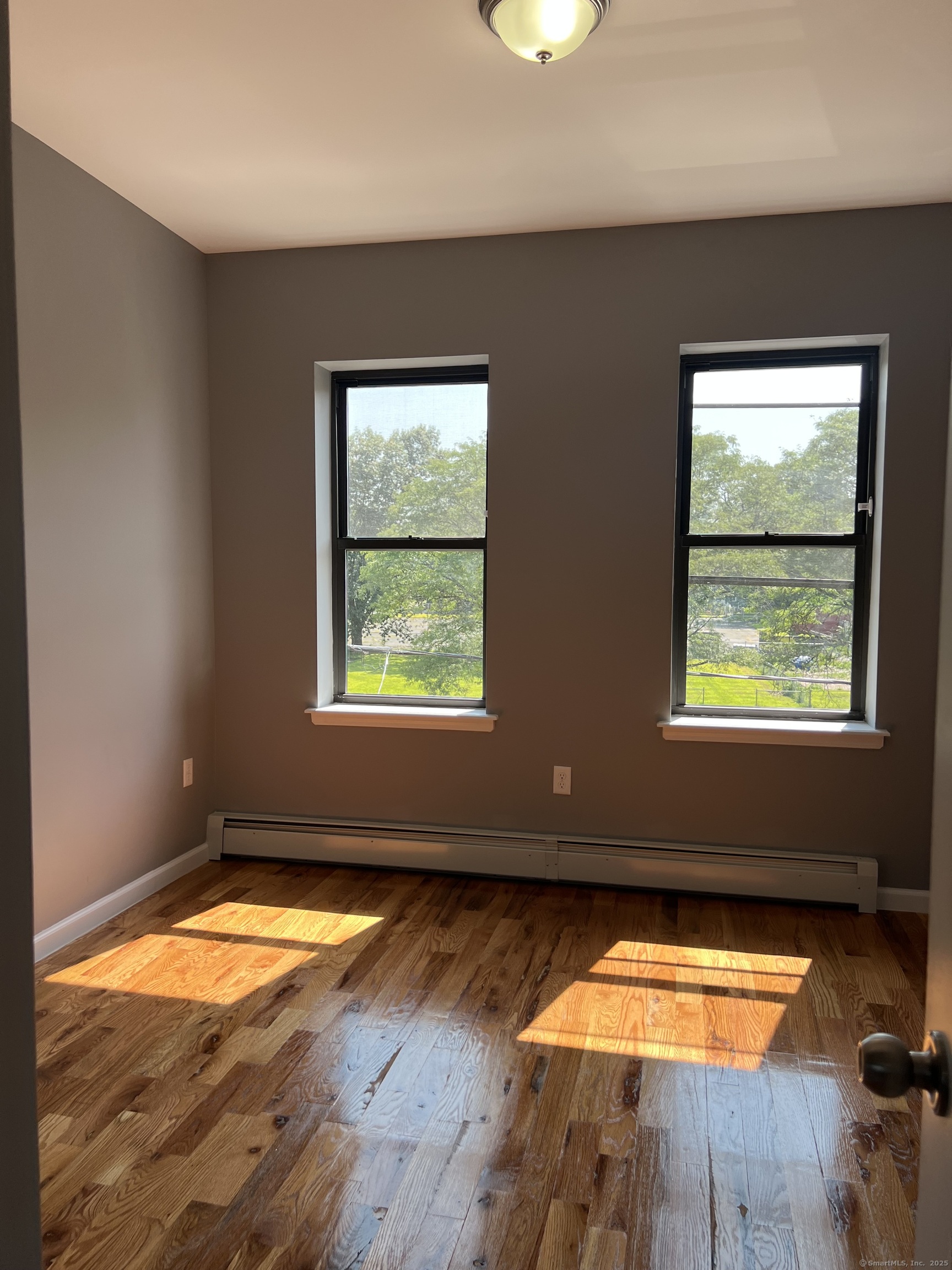 79 Barbour Street, Unit S1 Hartford, CT 06120 - Photo 5 of 8 an empty room with wooden floor and windows