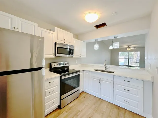 a kitchen with white cabinets and stainless steel appliances