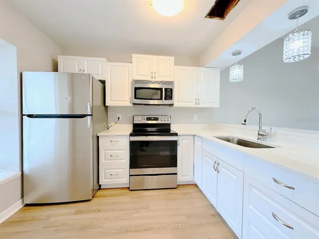a kitchen with a refrigerator stove and sink