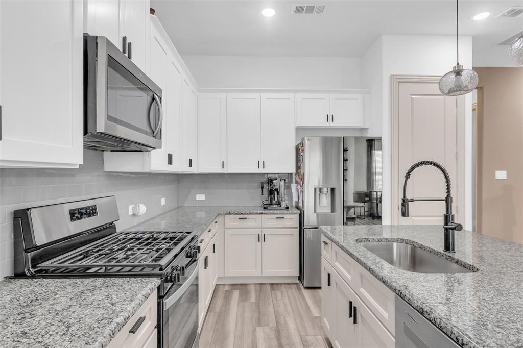4153 Shavano Drive Frisco, TX 75034 - Photo 14 of 35 a kitchen with stainless steel appliances granite countertop a sink stove refrigerator and cabinets