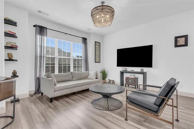 a living room with furniture a flat screen tv and a window