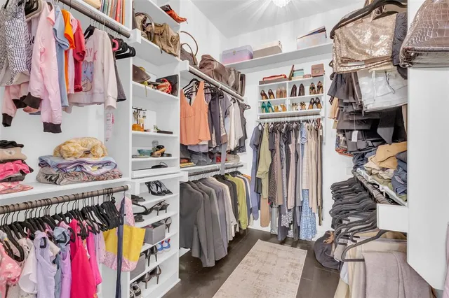 a view of walk in closet with clothes and shoes