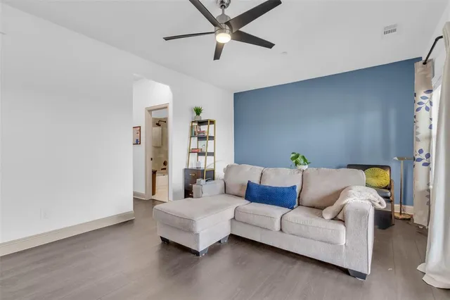 a living room with furniture and a ceiling fan