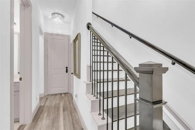 a view of staircase with railing and white walls