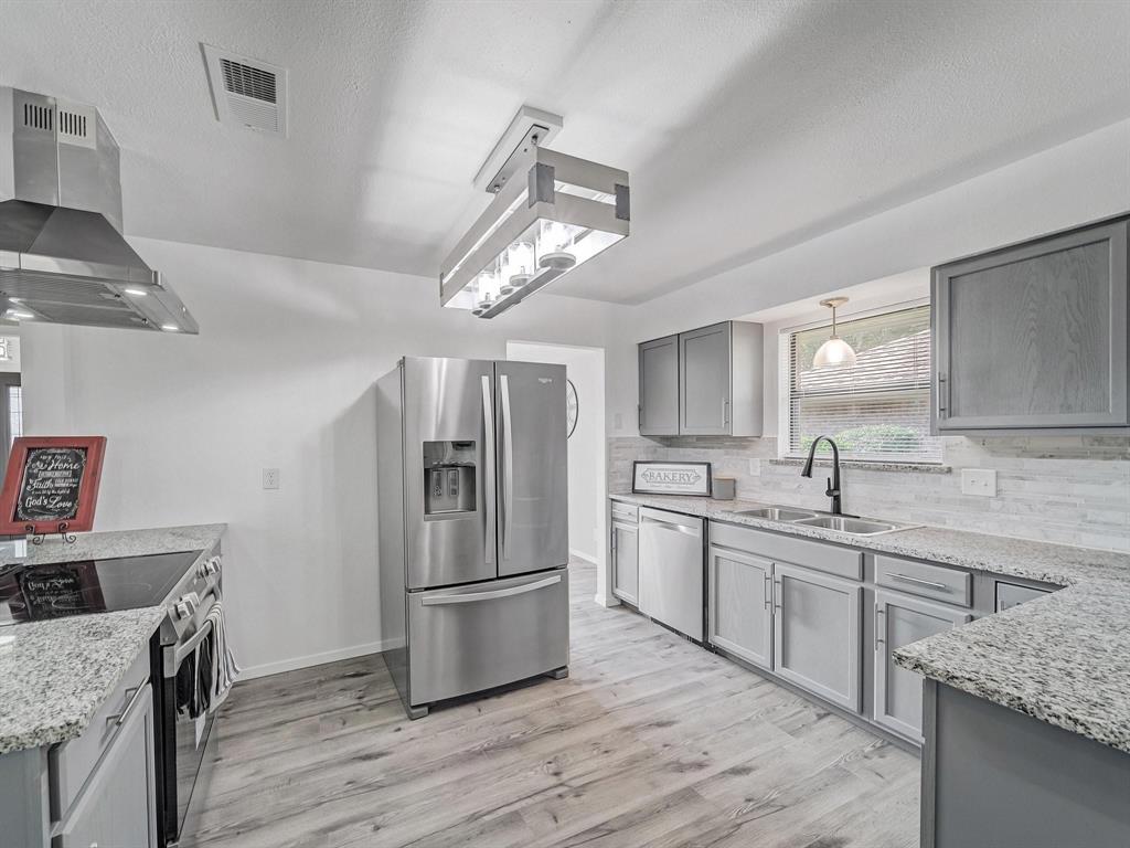 3105 Regency Carrollton, TX 75007 - Photo 6 of 18 a kitchen with stainless steel appliances granite countertop a sink stove and refrigerator