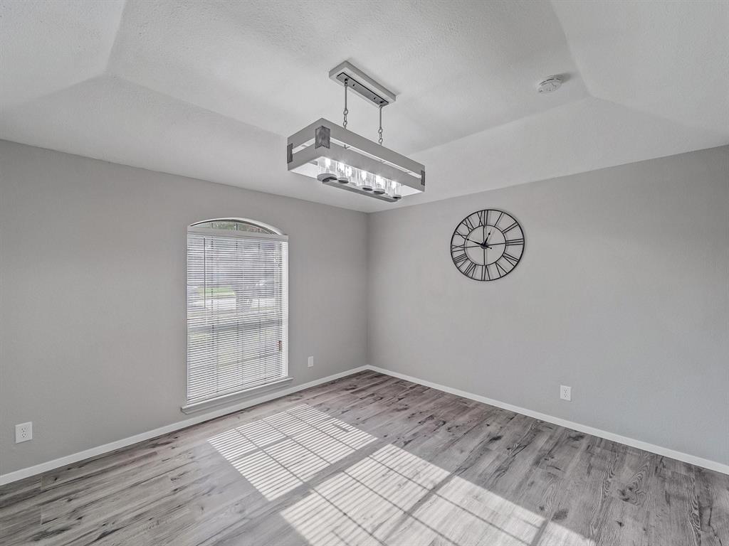 3105 Regency Carrollton, TX 75007 - Photo 9 of 18 an empty room with a chandelier fan and wooden floor