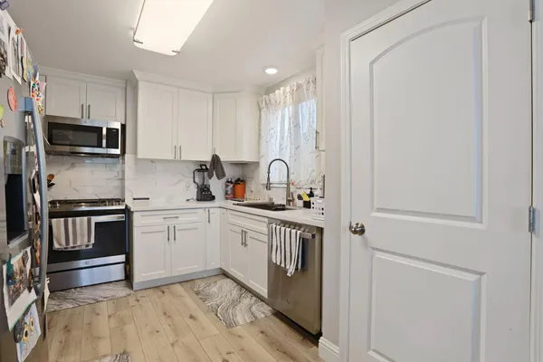 a kitchen with stainless steel appliances granite countertop a stove a sink and a refrigerator