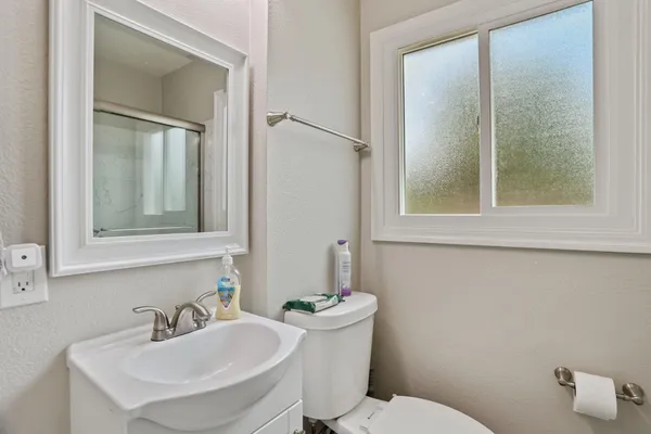 a bathroom with a toilet sink and mirror