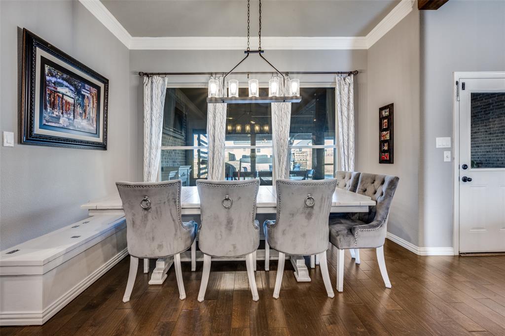 7417 Green Mesa Road Ponder, TX 76259 - Photo 16 of 39 a dining room with wooden floor a chandelier a wooden table and chairs