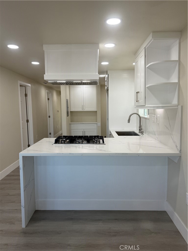 7700 Lampson Avenue, Unit 52 Garden Grove, CA 92841 - Photo 1 of 11 a kitchen with kitchen island a sink a stove a refrigerator and white cabinets
