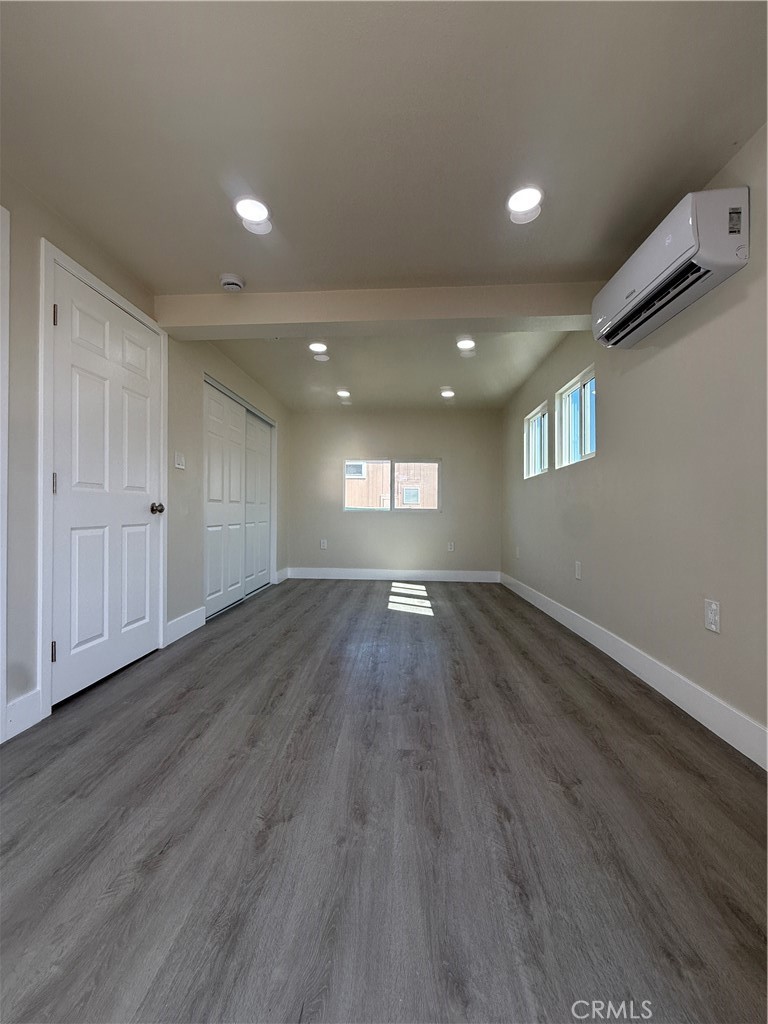 7700 Lampson Avenue, Unit 52 Garden Grove, CA 92841 - Photo 4 of 11 an empty room with wooden floor and windows